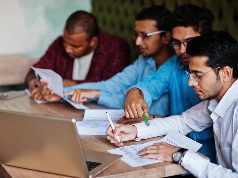 group-four-south-asian-men-s-posed-business-meeting-cafe-indians-together-sign-important-documents-contract-study-work