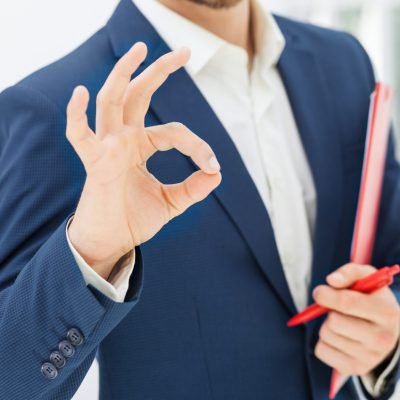 The hands of male office worker with a pen against white office