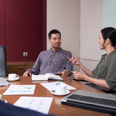 Vietnamese female business executive conducting meeting with employees